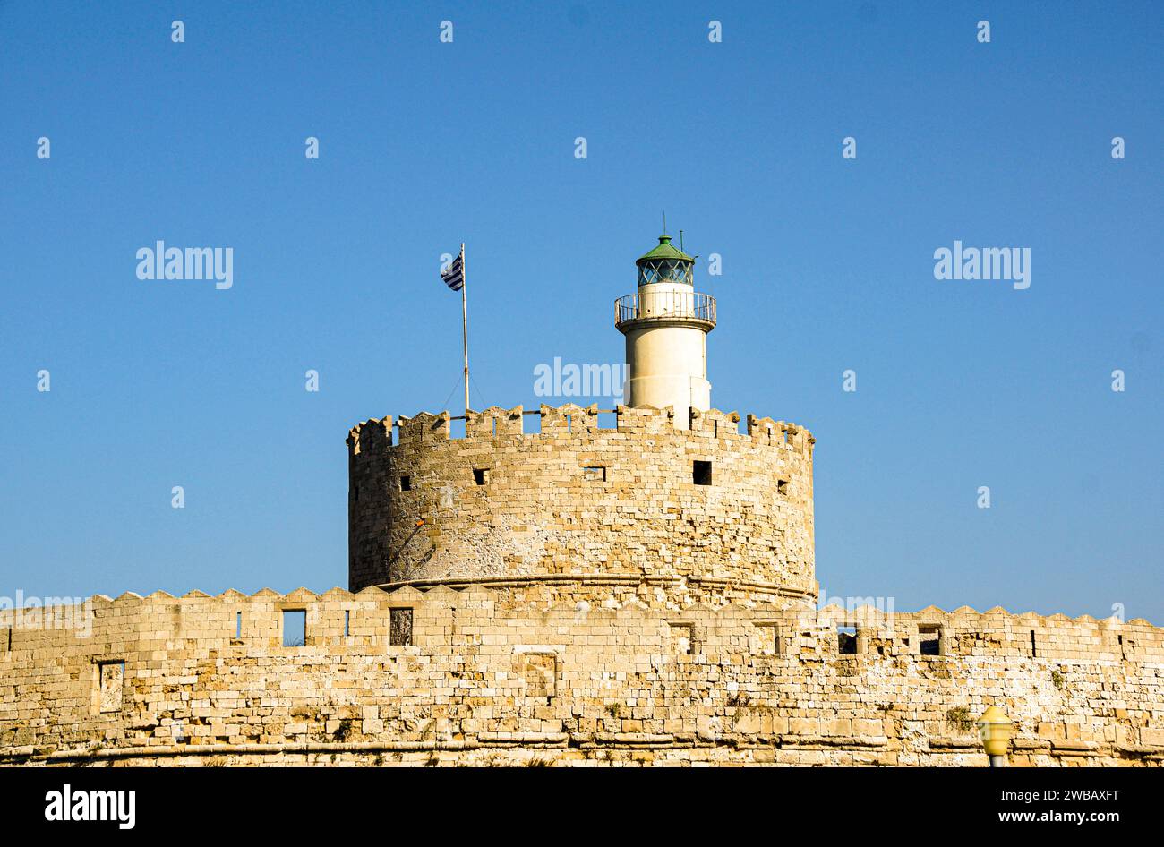 Parte di un castello greco con un faro su un'isola del mar egeo Foto Stock