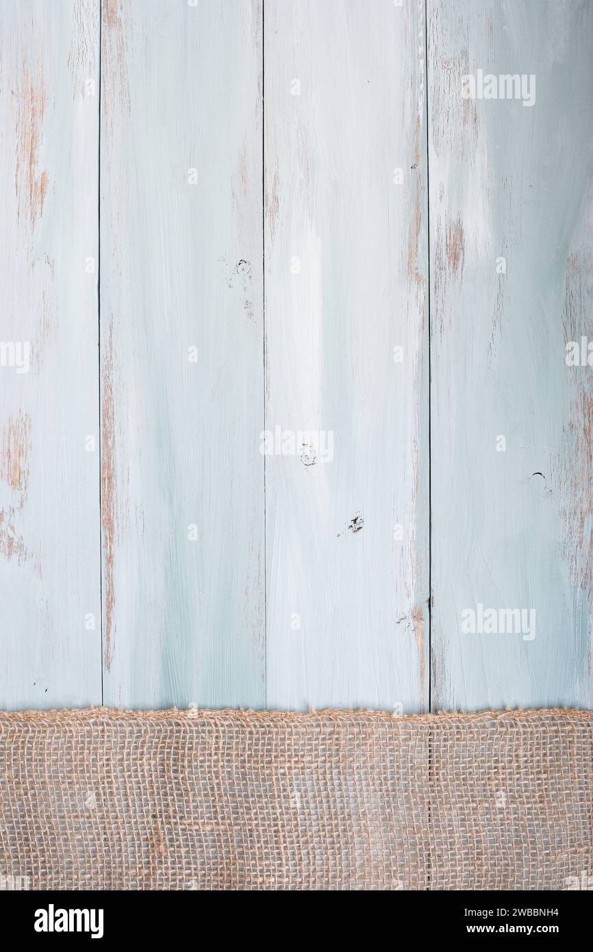 Sfondo in legno rustico blu e bianco con nastro di burlap che attraversa il fondo del tavolo. Vista dall'alto. Foto Stock