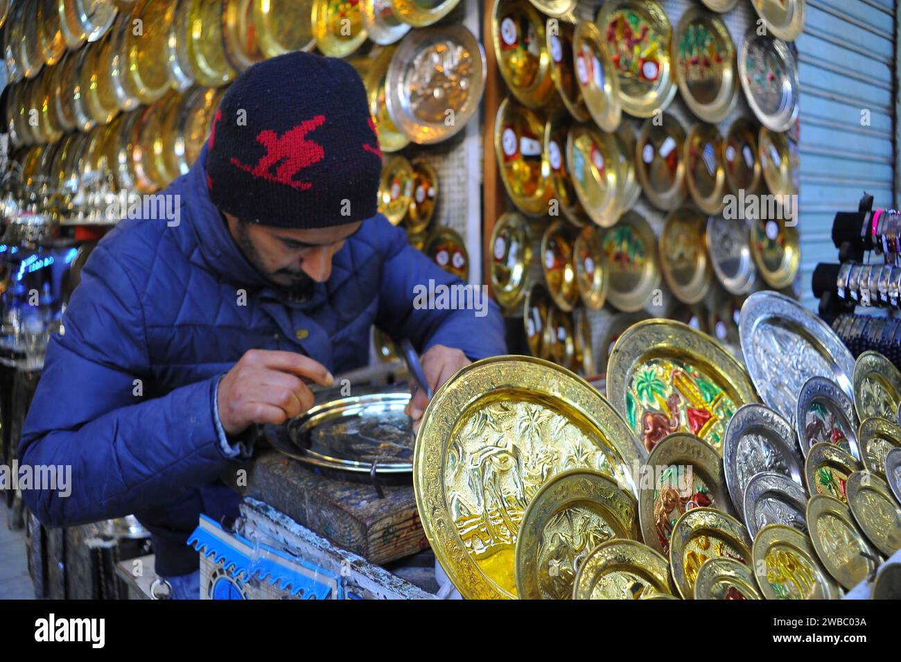Tunisi. 9 gennaio 2024. Un artigiano scolpisce i motivi su una ceramica di metallo nella Medina di Tunisi, Tunisia, il 9 gennaio 2024. Gli oggetti in metallo incisi sono i principali souvenir turistici della Tunisia. Le arti, le abilità e le pratiche associate all'incisione sui metalli, come oro, argento e rame, che sono ampiamente diffuse nei paesi arabi, sono state iscritte nel 2023 nella Lista rappresentativa del Patrimonio culturale immateriale dell'umanità. Crediti: Adel Ezzine/Xinhua/Alamy Live News Foto Stock