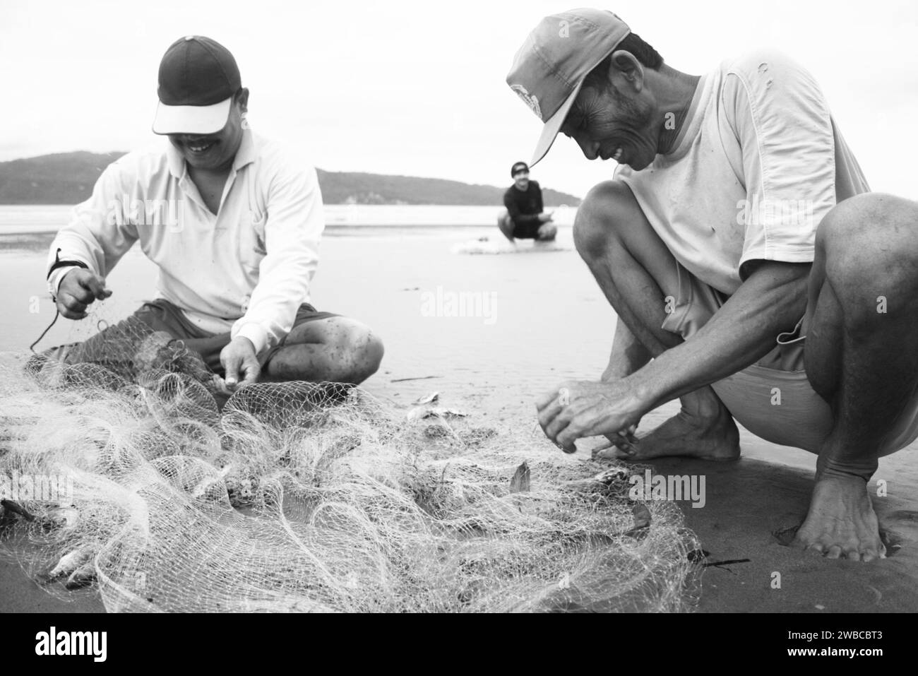 I pescatori della costa del Pacitan raccolgono i pesci che catturano sulla spiaggia Foto Stock