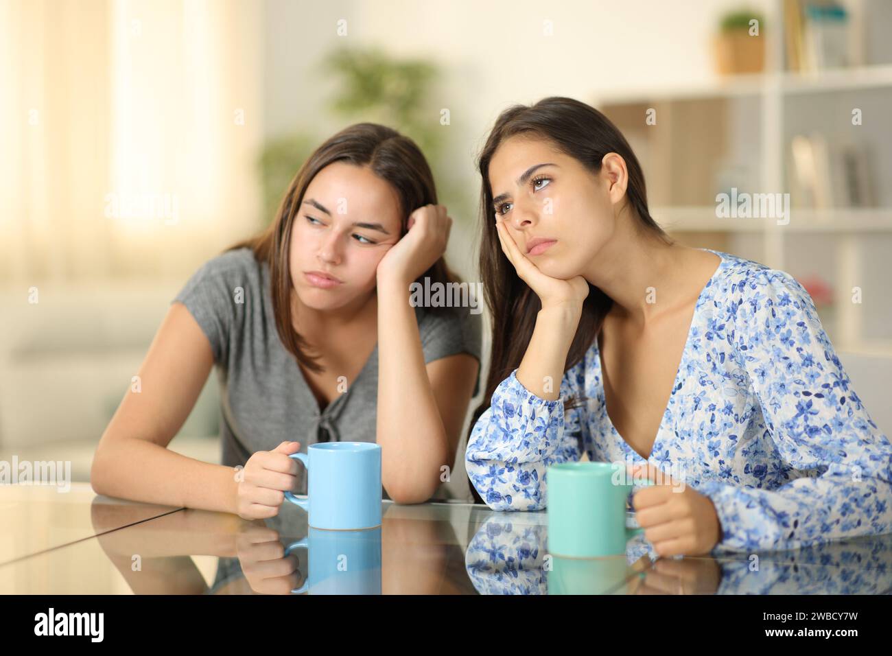 Due amici annoiati che bevono caffè insieme a casa Foto Stock