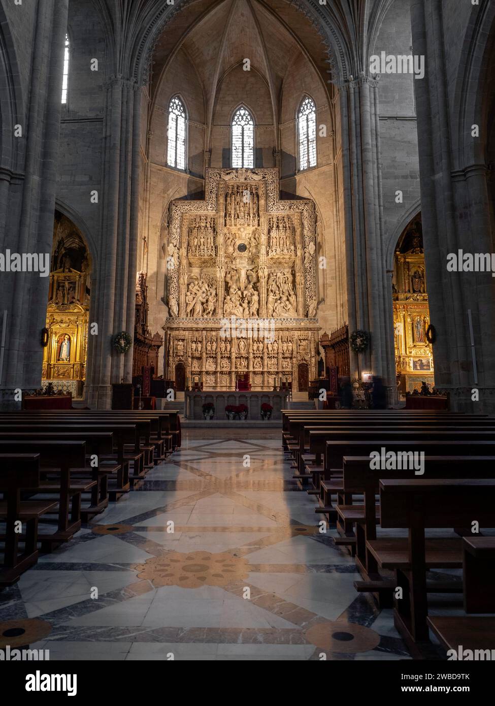 Interno gotico della cattedrale, luce del sole che illumina l'altare. Maestoso interno della cattedrale con pala d'altare decorata. Pala d'altare della Cattedrale di Huesca Damiand Foto Stock