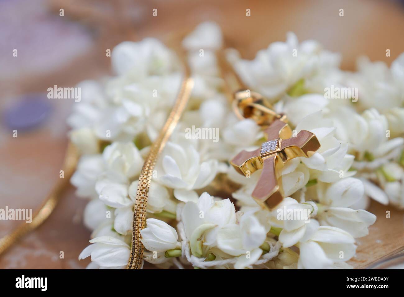 Una croce dietro i fiori di gelsomino bianco Foto Stock