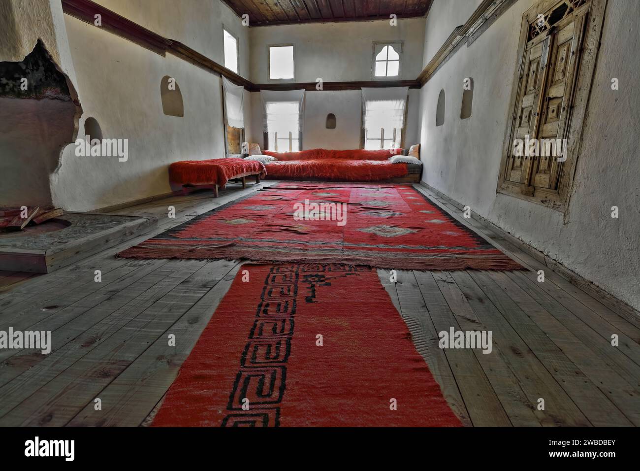 Soggiorno della casa ottomana dei primi 1700 anni '221 con tappeti kilim intrecciati a mano, divano e divano con coperta di pile cruda, enorme caminetto. Gjirokaster-Albania. Foto Stock