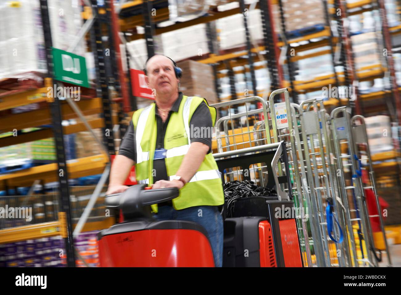 Uomo su un camion che si sposta in un moderno magazzino di distribuzione, nel sud-est dell'Inghilterra, Regno Unito Foto Stock