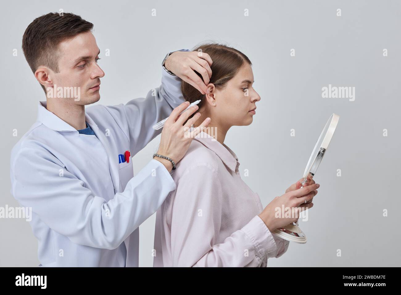 Marcatore di otoplastica per rimodellare chirurgicamente la pinna o orecchio esterno per correggere un'irregolarità e migliorare l'aspetto. Contrassegno medico chirurgo gir Foto Stock
