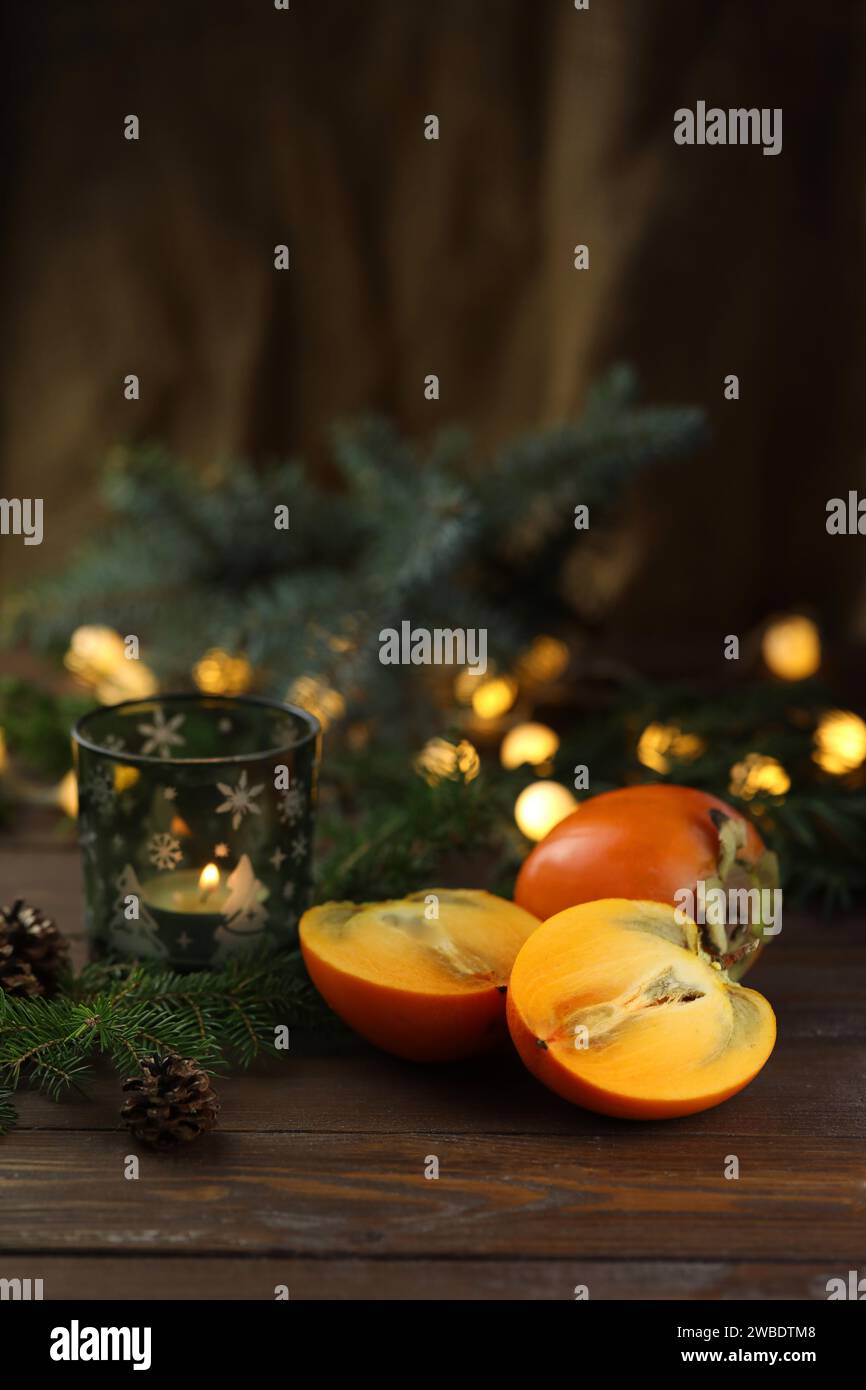 Cachi arancioni brillanti tagliati su fondo di legno Foto Stock