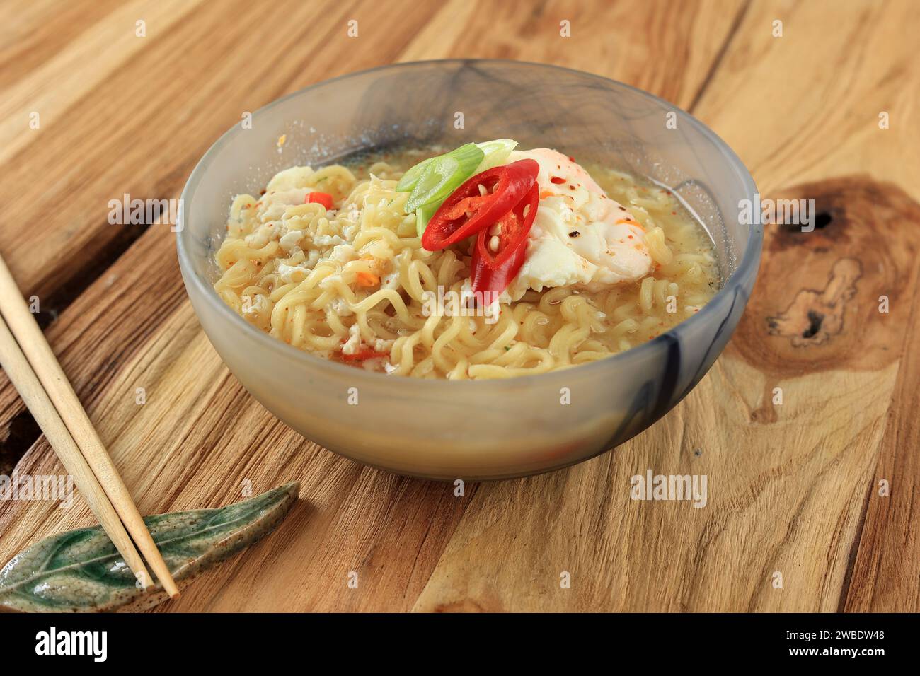 Torta Kuah piccante o zuppa di spaghetti istantanei con uovo condito con cipolla verde e peperoncino rosso Foto Stock