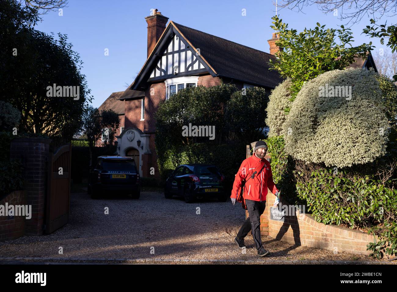 Un postino della Royal mail consegna il suo giro giornaliero all'ex CEO del Royal Mair Group Adam Croziers Property a Weybridge, Surrey, Inghilterra Foto Stock