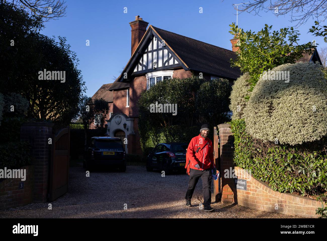 Un postino della Royal mail consegna il suo giro giornaliero all'ex CEO del Royal Mair Group Adam Croziers Property a Weybridge, Surrey, Inghilterra Foto Stock