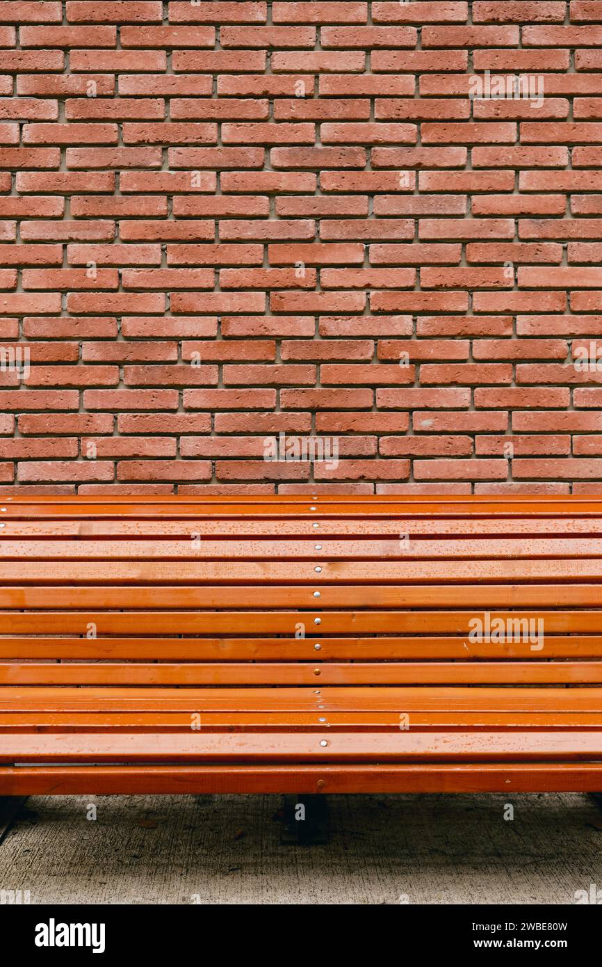Striscione verticale con panca su sfondo rosso-marrone in mattoni vintage, concept per pubblicità su sfondo murale in mattoni Foto Stock