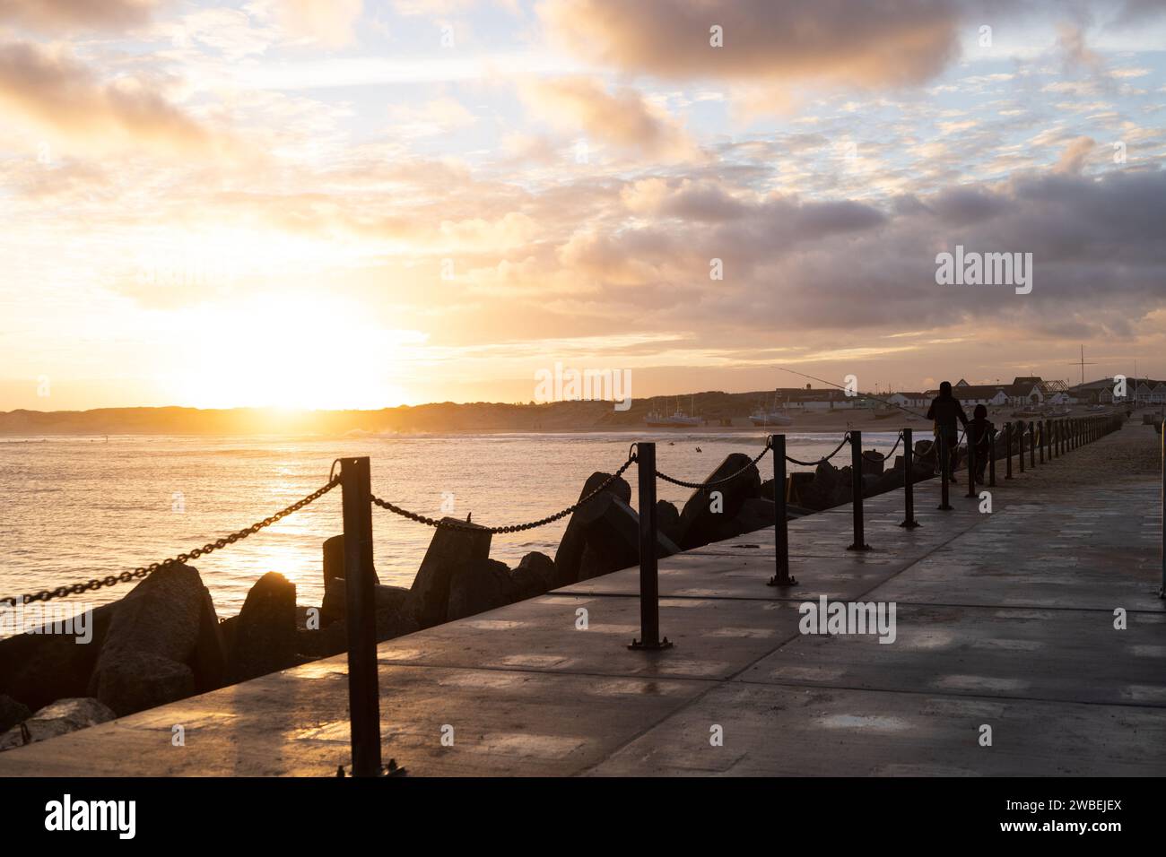 Un bordo di un molo, che guarda all'orizzonte mentre il sole inizia a tramontare. Foto Stock