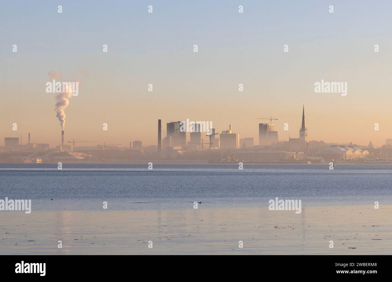 Una vista panoramica dello skyline di Tallinn in Estonia con uno spesso strato di smog, concetto di inquinamento atmosferico Foto Stock