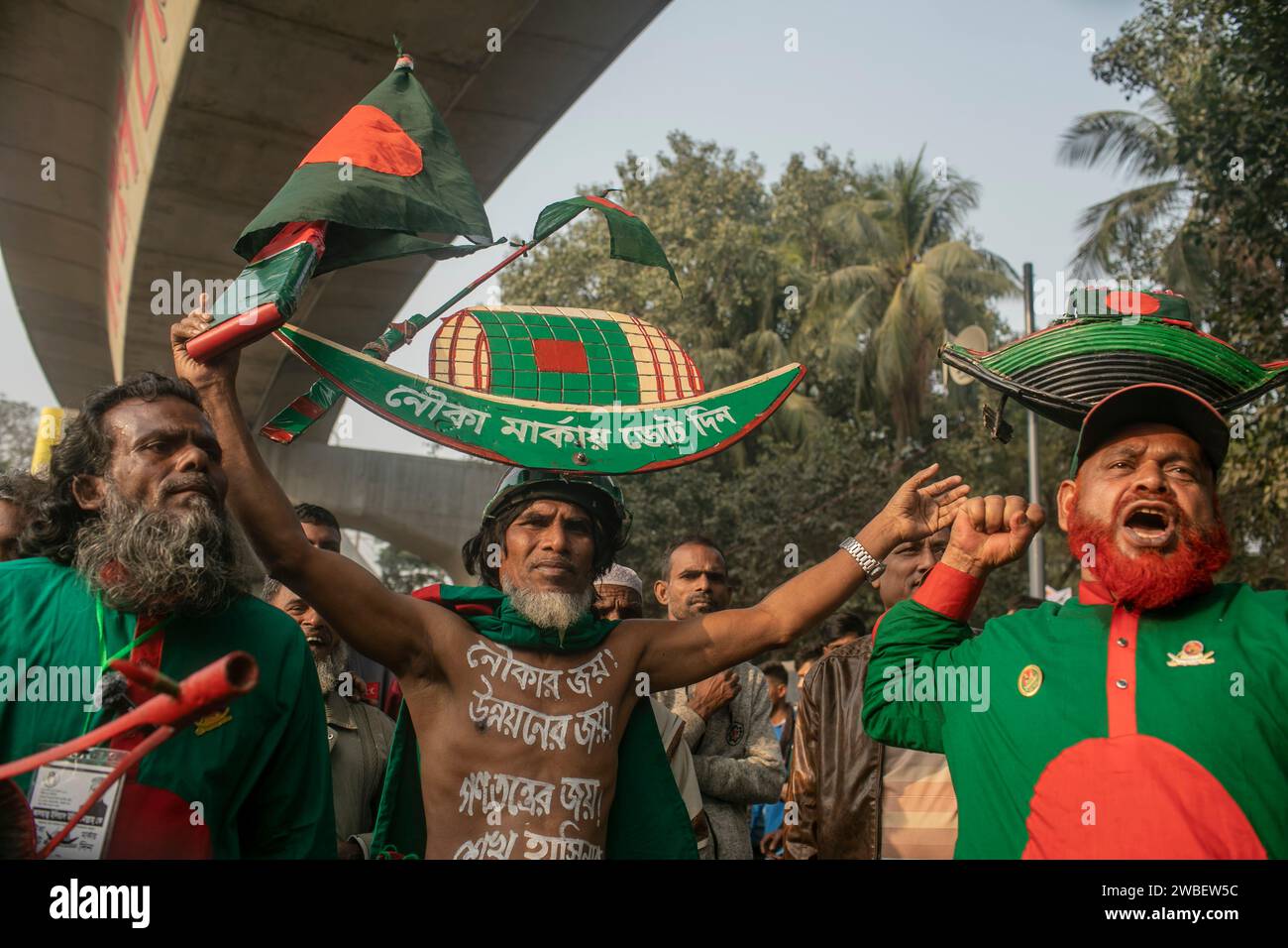 Dhaka, Bangladesh. 10 gennaio 2024. I sostenitori del partito al governo del Bangladesh Awami League cantano e portano in testa il simbolo elettorale del partito mentre arrivano a Suhrawardy Udyan per partecipare a una manifestazione pubblica. I leader e gli attivisti della Lega Awami si sono riuniti a Suhrawardy Udyan per partecipare a una manifestazione pubblica organizzata per commemorare lo storico giorno del ritorno a casa del padre della Nazione, Bangabandhu Sheikh Mujibur Rahman. Credito: SOPA Images Limited/Alamy Live News Foto Stock