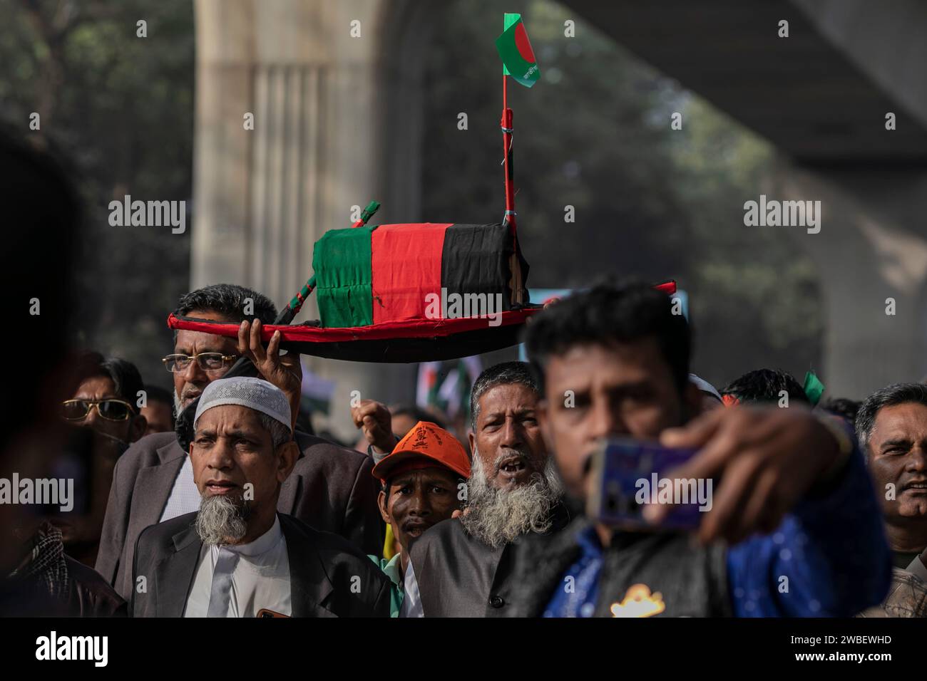 Un sostenitore del partito al governo del Bangladesh Awami League con il simbolo elettorale del partito barca sulla sua testa mentre arriva Suhrawardy Udyan per partecipare a una manifestazione pubblica. I leader e gli attivisti della Lega Awami si sono riuniti a Suhrawardy Udyan per partecipare a una manifestazione pubblica organizzata per commemorare lo storico giorno del ritorno a casa del padre della Nazione, Bangabandhu Sheikh Mujibur Rahman. (Foto di Sazzad Hossain / SOPA Images/Sipa USA) Foto Stock