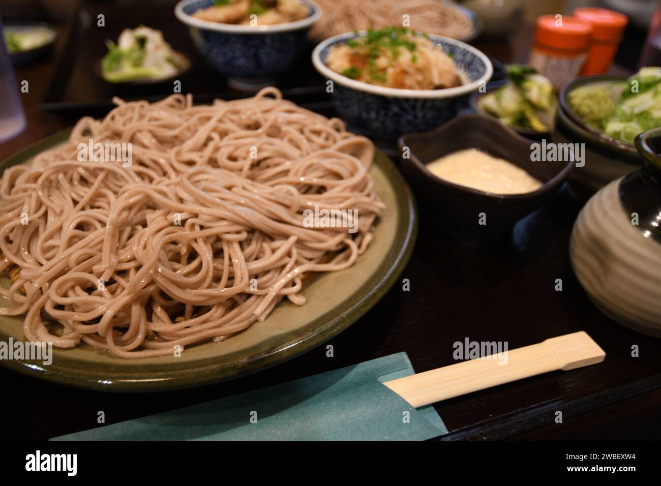 Un tavolo in legno adornato da una vibrante collezione di cucina asiatica Foto Stock
