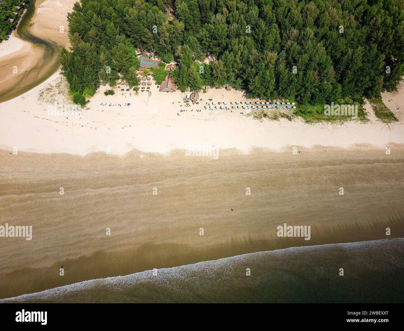 Vista aerea dall'alto degli ombrelloni su una grande e tranquilla spiaggia tropicale con bassa marea Foto Stock