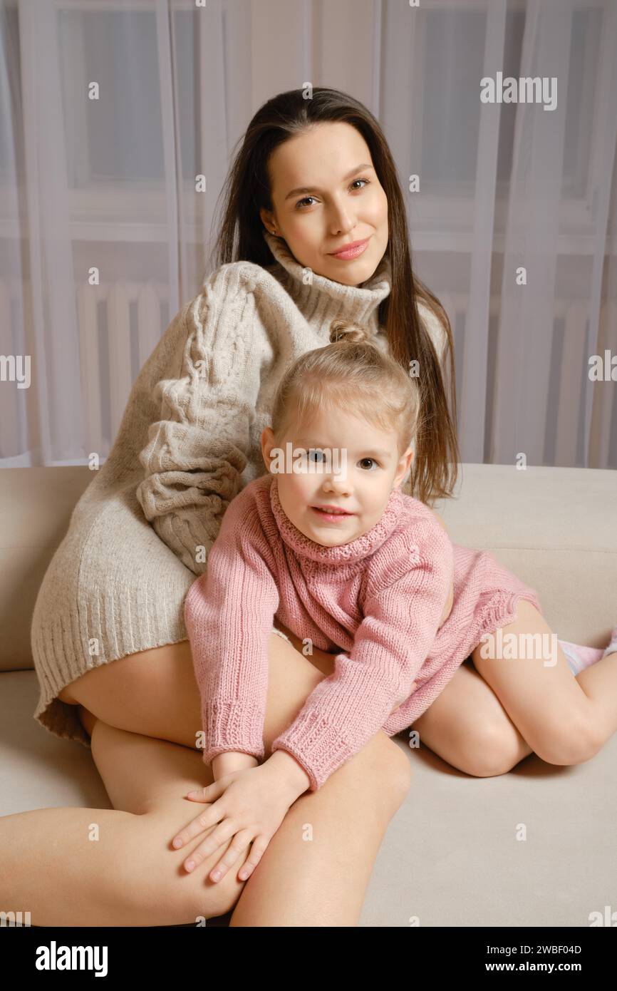 Ritratto lifestyle di una giovane madre e di una piccola figlia sul divano di casa Foto Stock