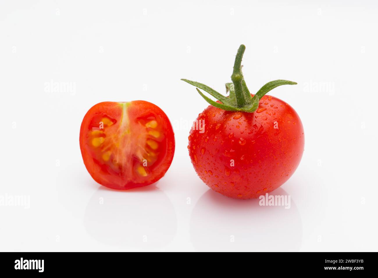 Un pomodoro fresco, pomodori, due, studio shot, tagliato, pomodoro, frutta, verdura, gocce d'acqua Foto Stock