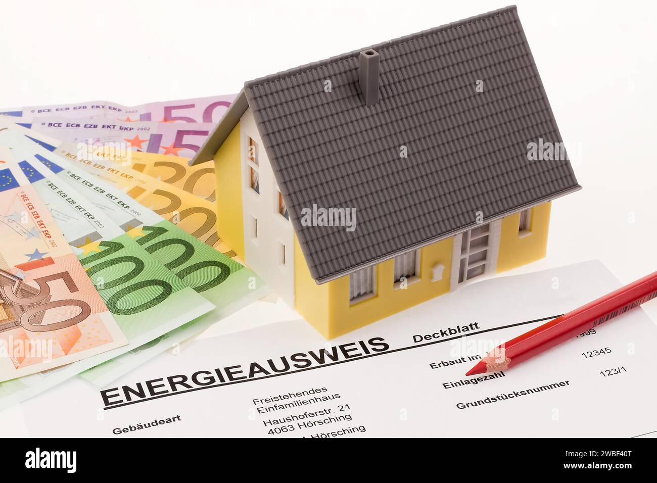 Un certificato energetico con una casa indipendente e banconote in euro Foto Stock