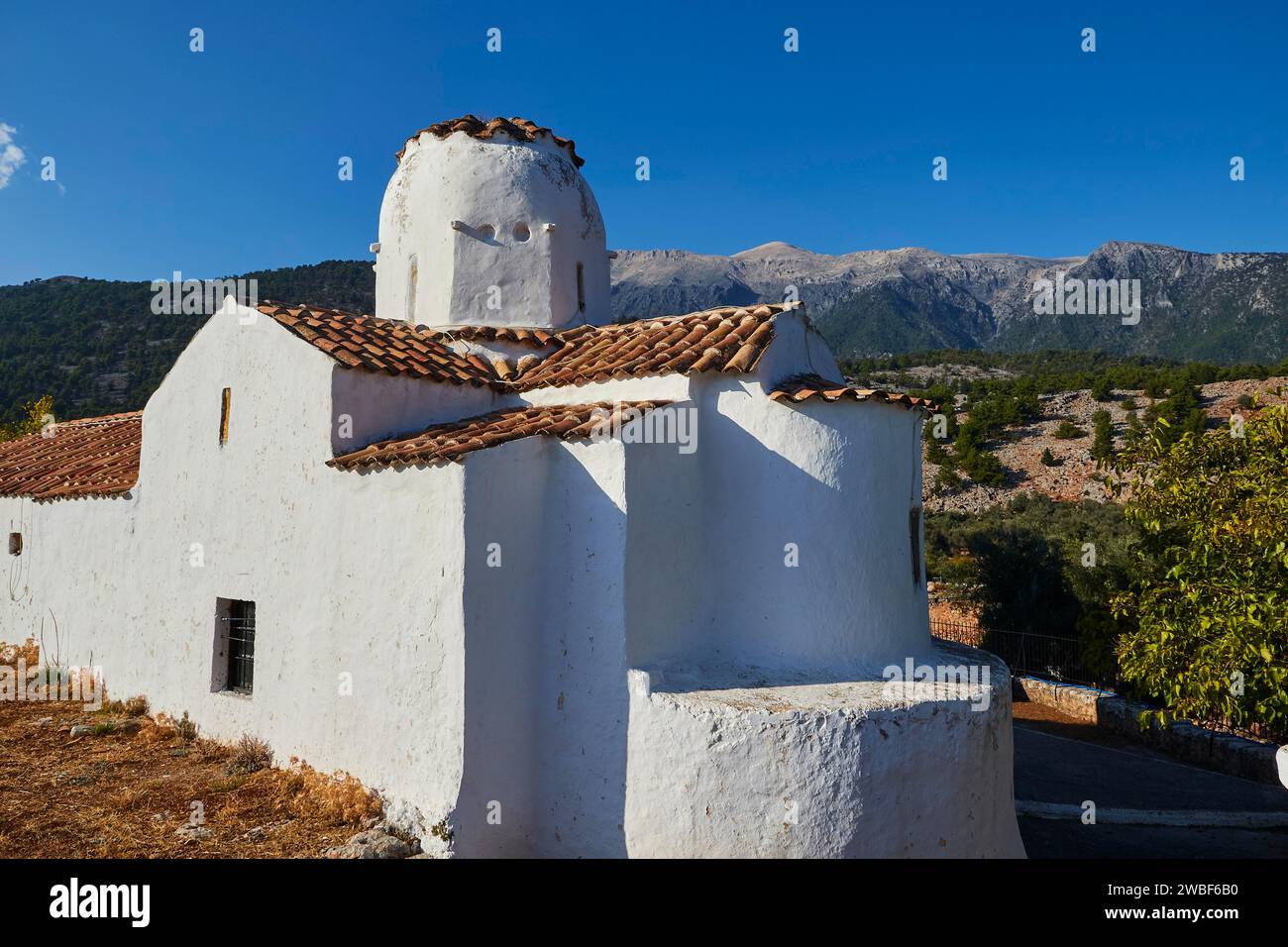 Chiesa di San Michele Arcangelo, chiesa a cupola a croce, chiesa bianca con cupola arrotondata su un imponente sfondo di montagna e cielo blu, Aradena Foto Stock