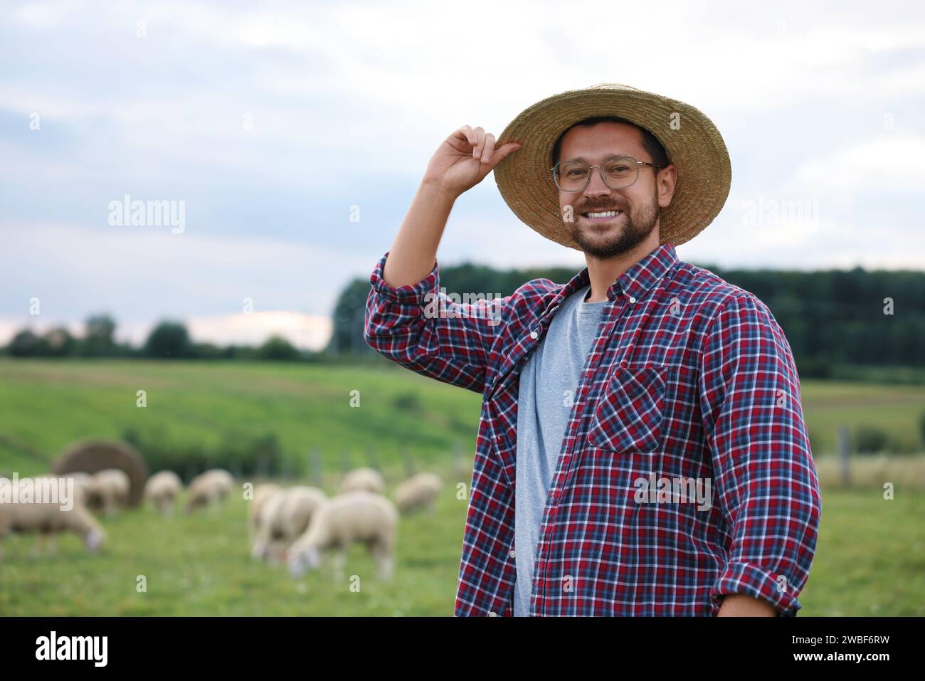 Ritratto di un uomo sorridente al pascolo della fattoria. Spazio per il testo Foto Stock