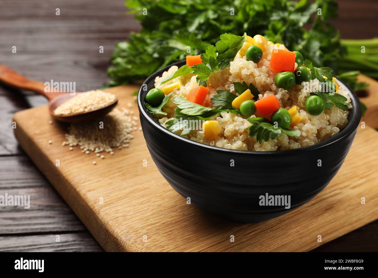 Delizioso porridge di quinoa con verdure in ciotola su tavolo di legno, primo piano Foto Stock