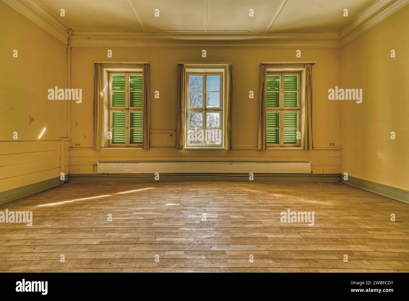 Camera luminosa con pavimento in legno e tre finestre con persiane verdi chiuse, Villa Schachtrupp, Lost Place, Osterode am Harz, Lower Foto Stock