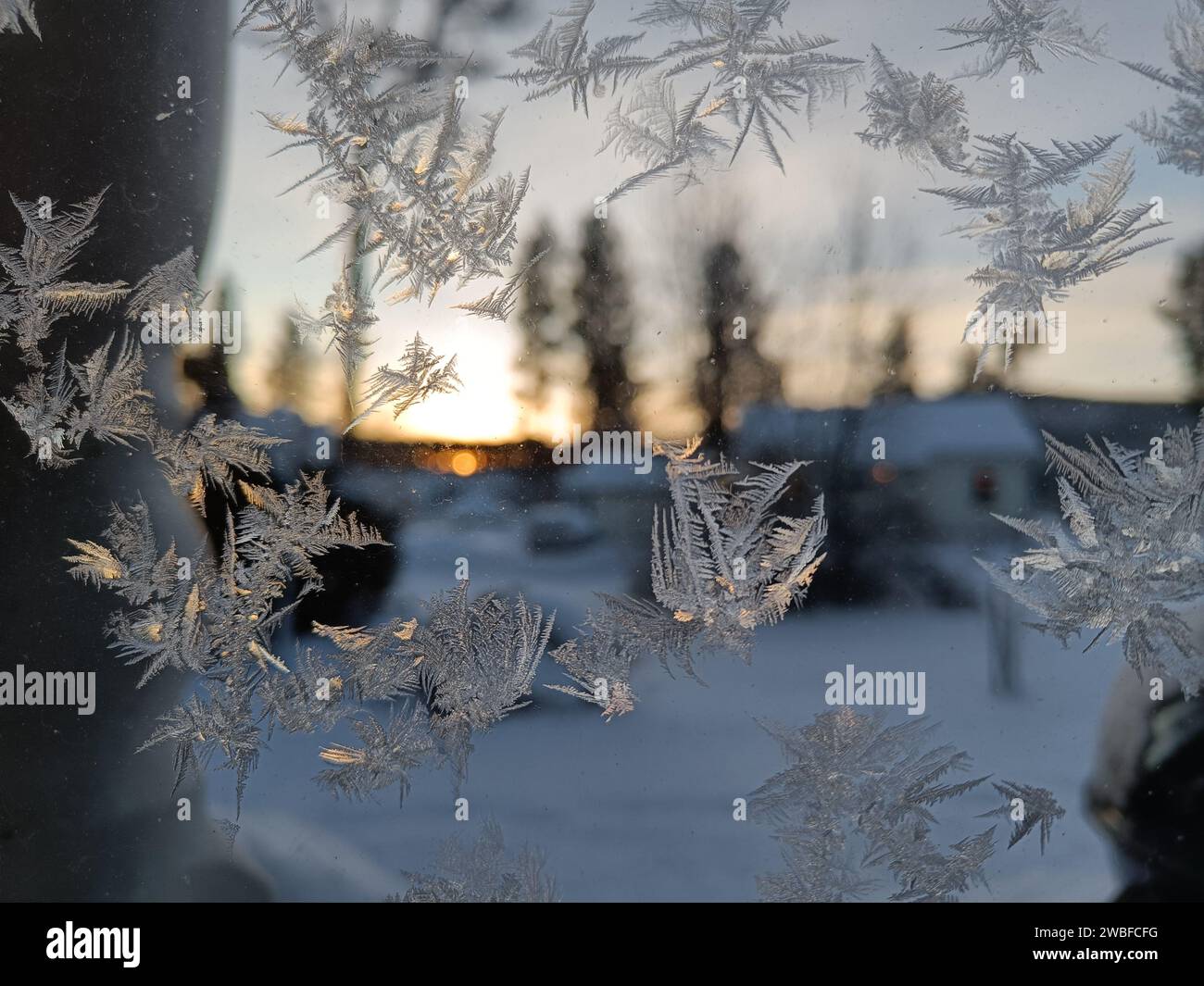 Modelli di gelo sulla finestra invernale ghiacciata come simbolo della meraviglia di Natale. Al centro della finestra c'è uno spazio confuso per il prodotto o la scritta. C Foto Stock
