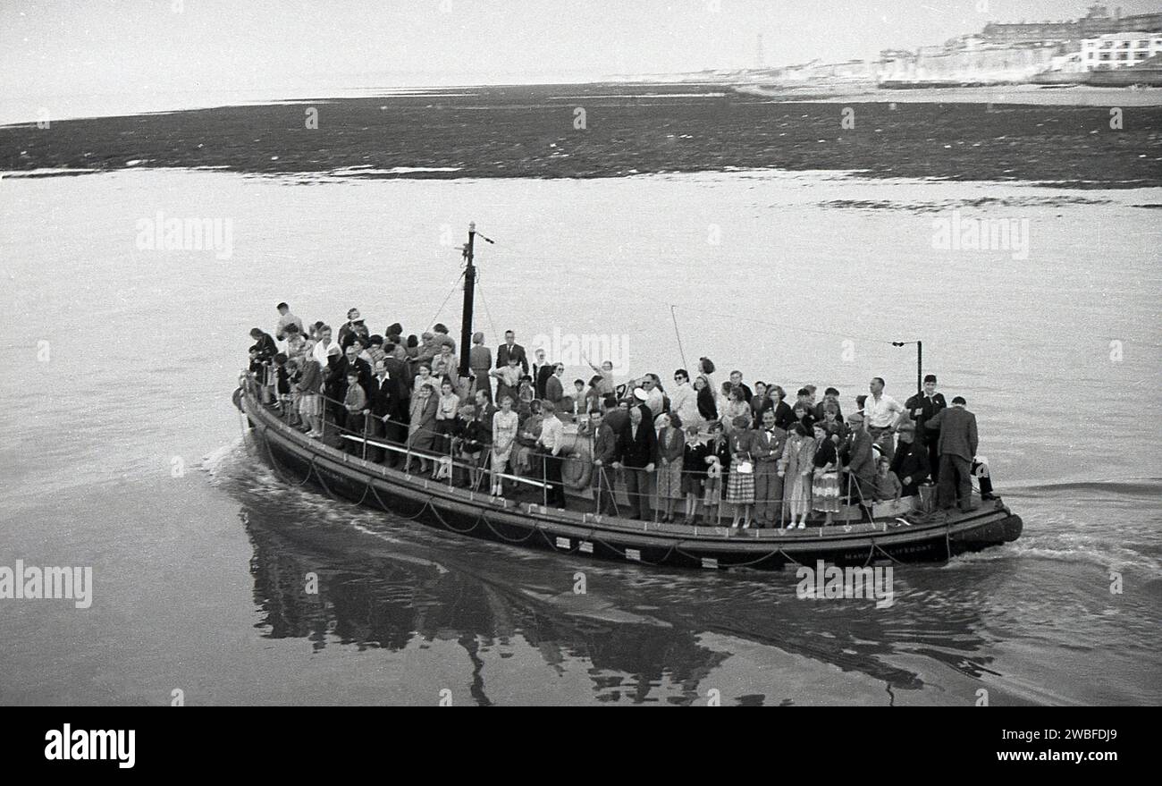 1960, storico, un gruppo di vacanzieri che fanno un giro sul battello di salvataggio Margate, Margate, Kent, Inghilterra, Regno Unito. La cabina e lo scalo per la nave di salvataggio RNLI furono aggiunti al molo di Margate nel 1898 e funzionarono fino al 1978, quando una grave tempesta distrusse la maggior parte del molo che era già stato chiuso due anni prima a causa di problemi di sicurezza. Foto Stock