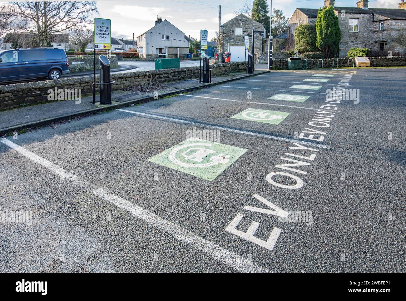Gargrave, North Yorkshire spazi vuoti solo per veicoli elettrici in un'area di parcheggio altrimenti piena--- prepararsi per il futuro, Foto Stock