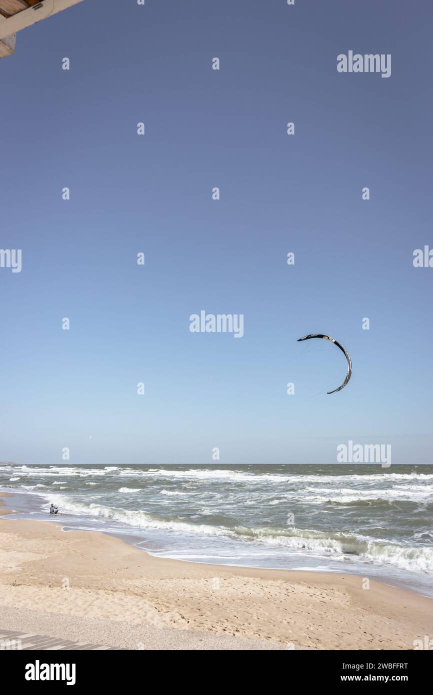 Kite surf sulla spiaggia. Stile di vita attivo. Concetto di sport estremi. Uomo in muta con aquilone al mare. Sport attivi estivi. Foto Stock