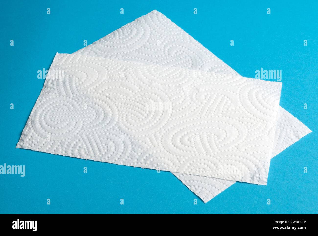 Pezzi di carta bianca in rotoli su sfondo blu Foto Stock