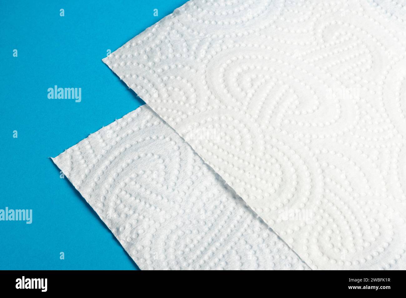 Pezzi di carta bianca in rotoli su sfondo blu Foto Stock