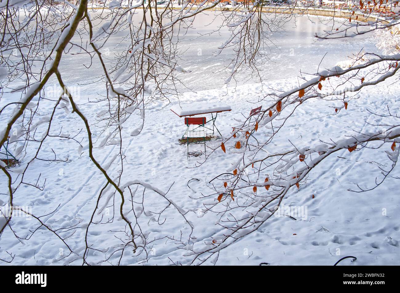 Tavolo e sedia ricoperti di neve in un bianco paesaggio invernale Foto Stock