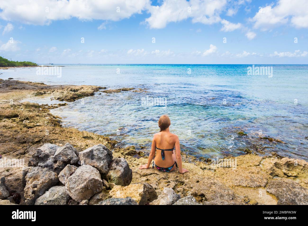 Bella giovane donna che si rilassa durante le vacanze. Foto del paesaggio scattata nell'isola di Cozumel in Messico durante la giornata di sole. Foto Stock