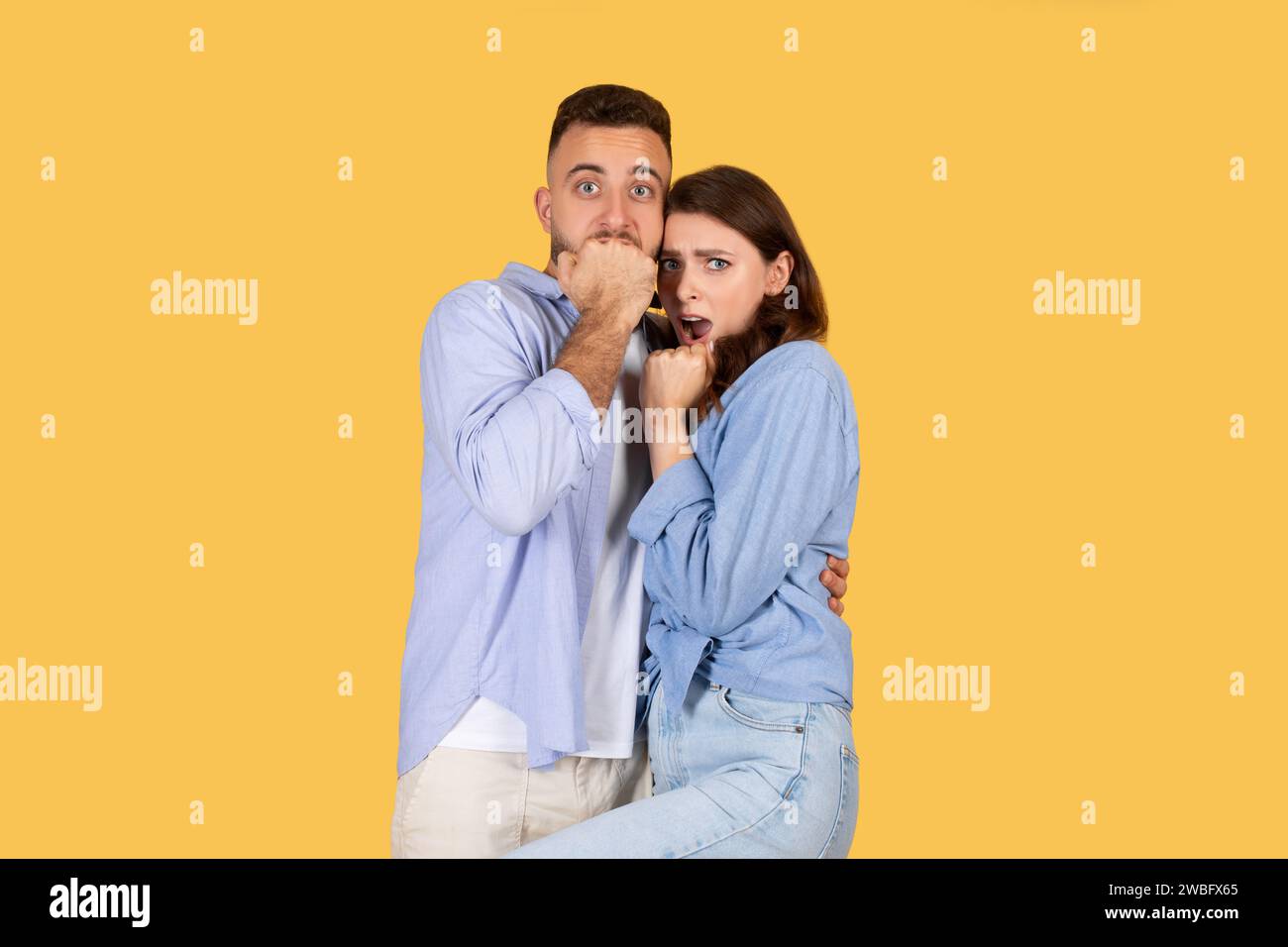 Coppia sorpresa con un uomo che si copre la bocca e una donna che sembra scioccata Foto Stock