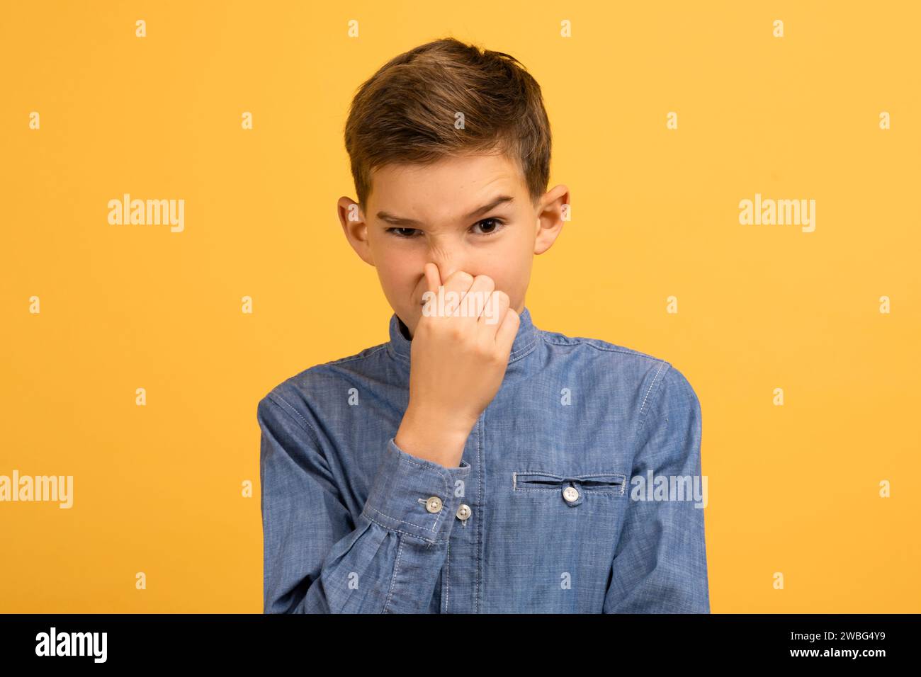 Un adolescente scontento che si copre il naso per evitare il cattivo odore Foto Stock