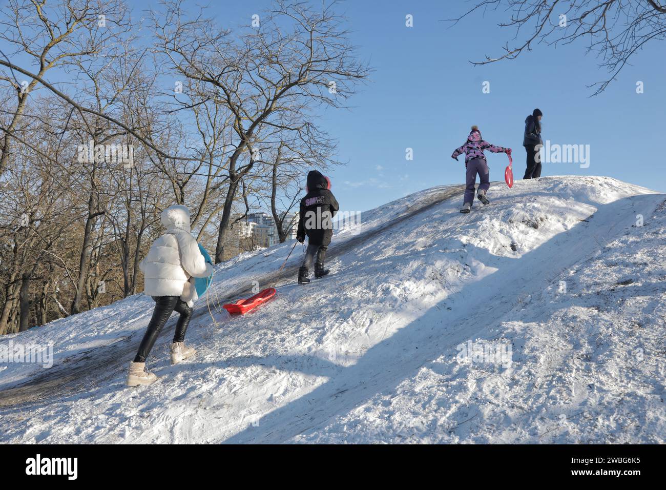Non esclusiva: ODESA, UCRAINA - 10 GENNAIO 2024 - i bambini vanno in salita mentre si divertono a fare slittino nel Parco della Vittoria di Premohy, Odesa, Ucraina meridionale. Foto Stock