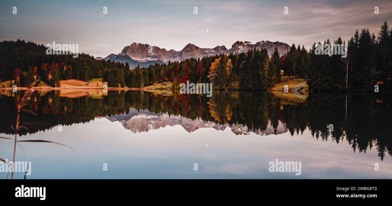 Un lago panoramico circondato da maestosi pini, con le rilassanti sfumature blu-verdi dell'acqua che riflettono il paesaggio circostante Foto Stock