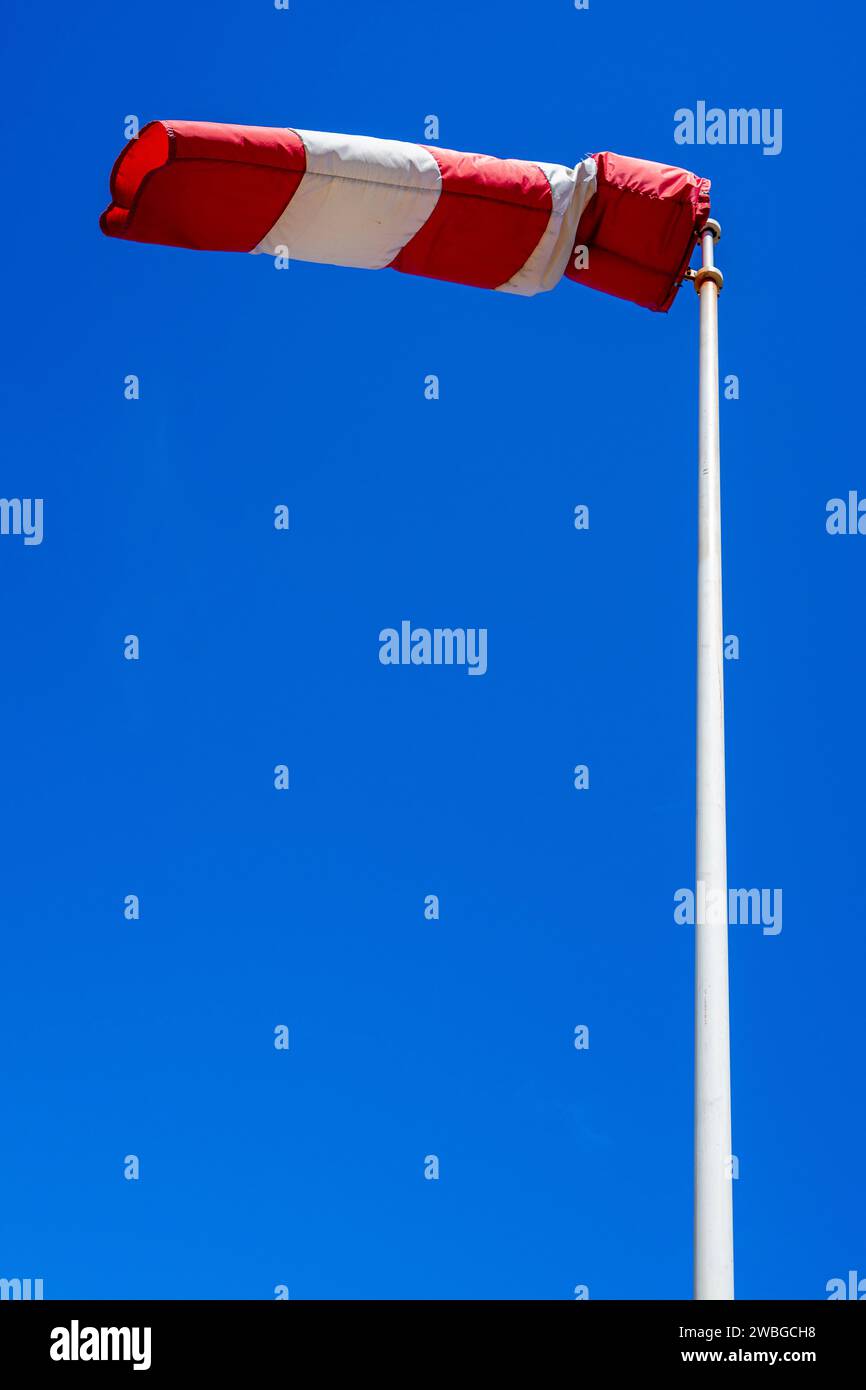 calza a vento in funzione con un forte sfondo blu del cielo. Foto Stock