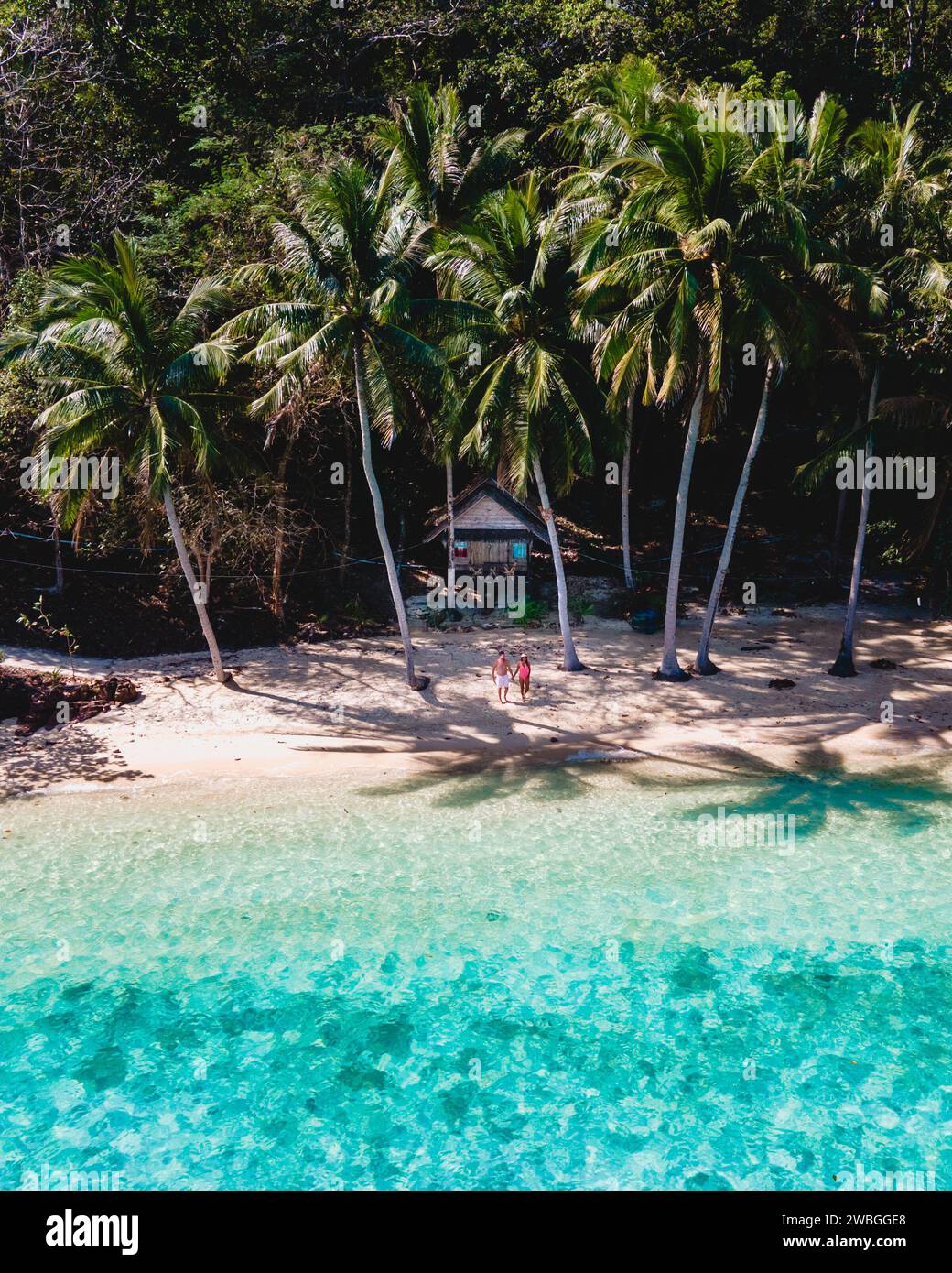 Koh Wai Island Trat Thailandia. bungalow in legno di bamboo sulla spiaggia con palme e mare color turchese. una giovane coppia di uomini e donne su un Foto Stock