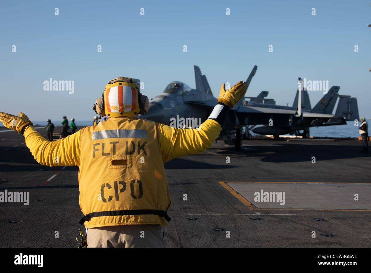 Il Chief Aviation Boatswain's Mate (Handling) Albert Mendez, assegnato al dipartimento aereo della più grande portaerei del mondo, la USS Gerald R. Ford (CVN 78), dirige un F/A-18E Super Hornet, attaccato al 'Golden Warriors' dello Strike Fighter Squadron (VFA) 87 durante le operazioni di volo di routine nel Mar Mediterraneo, 19 dicembre, 2023. Gli Stati Uniti mantengono forze schierate in avanti, pronte e posturate per scoraggiare l'aggressione e sostenere la sicurezza e la stabilità in tutto il mondo. (Foto della Marina degli Stati Uniti di Mass Communication Specialist 2nd Class Jacob Mattingly) Foto Stock