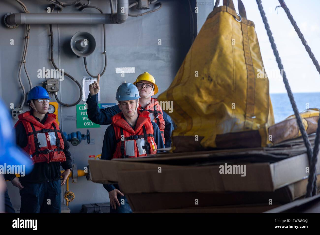 231229-N-OM737-1019 MAR MEDITERRANEO (29 dicembre 2023) Deck Department Sailors Assigned to Wasp-class anfibio Assault Ship USS Bataan (LHD 5) offload pallet durante un rifornimento in mare con la classe Henry J. Kaiser Replenishment Oiler USNS Laramie (T-AO 203), dicembre 29. Bataan è in un dispiegamento programmato nell'area operativa delle forze navali statunitensi in Europa, impiegato dalla Sesta flotta statunitense per difendere gli interessi alleati e partner degli Stati Uniti. (Foto della Marina degli Stati Uniti di Mass Communication Specialist 2nd Class Bradley Rickard) Foto Stock