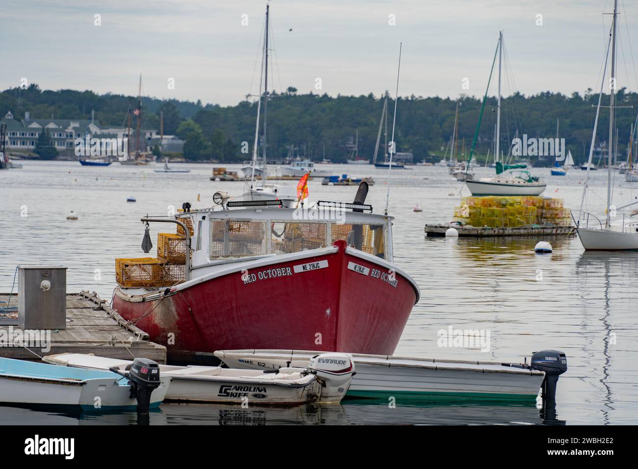 Porto di Boothbay, Maine - 13 luglio 2021: Barca per aragoste ormeggiata e trappole per aragoste impilate sul molo di Boothbay Harbor, Maine Foto Stock