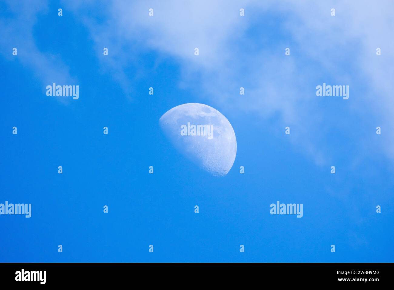 La Luna è nel cielo nuvoloso blu in una foto naturale di giorno Foto Stock