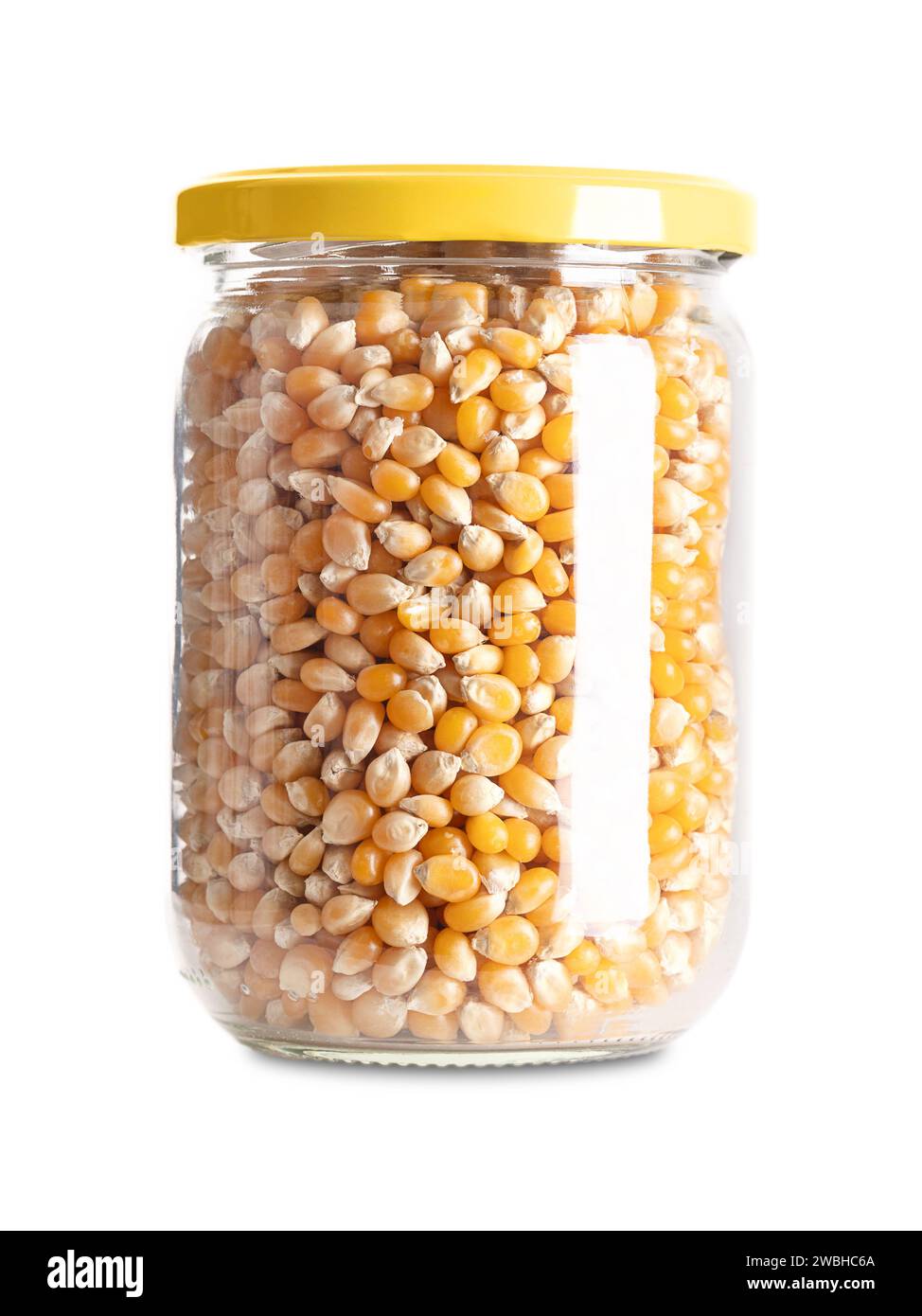 Popcorn non srotolati in un vaso di vetro con tappo a vite. Semi gialli di un tipo di granturco che si espande dal chicco e sbuffa quando riscaldato. Foto Stock