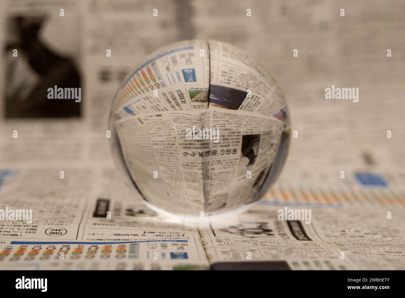 Un globo di vetro rivela le lettere all'interno, con un giornale sullo sfondo. Foto Stock