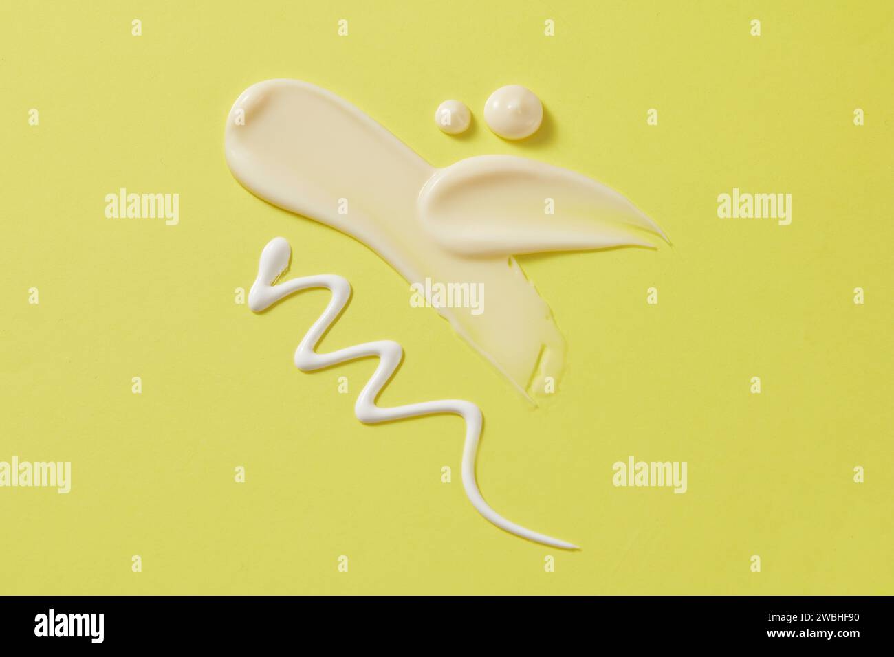 Le striature cremose di crema idratante, lozione e crema solare vengono visualizzate su uno sfondo verde pastello. Scenografia minimalista con spazio per design, pubblicità e. Foto Stock