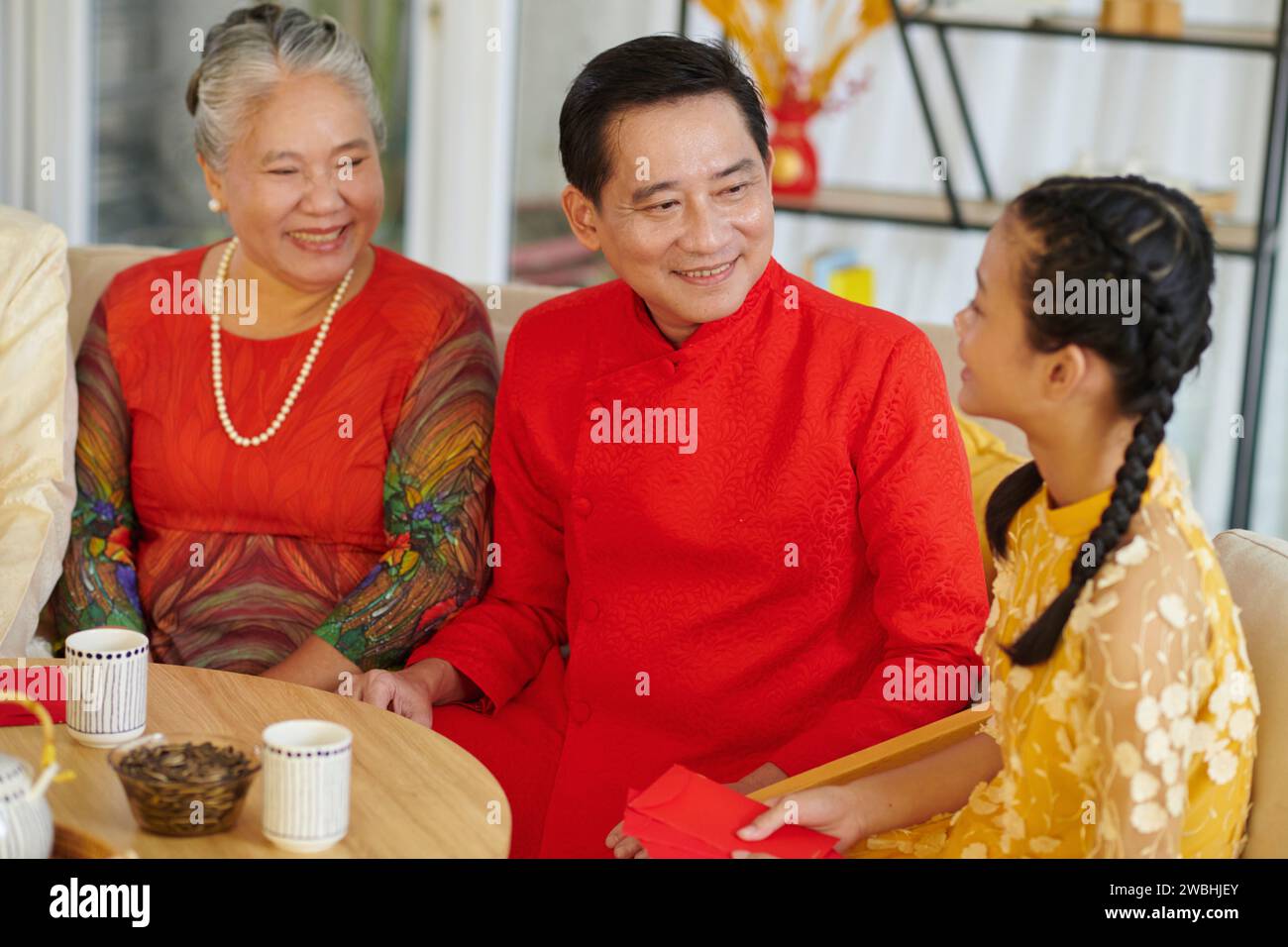 La famiglia vietnamita si è riunita per gustare un tè con prelibatezze e festeggiare il Capodanno lunare Foto Stock